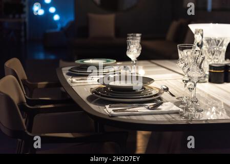 Stilvoller Dinner-Service im Low lit Designer Apartment Stockfoto