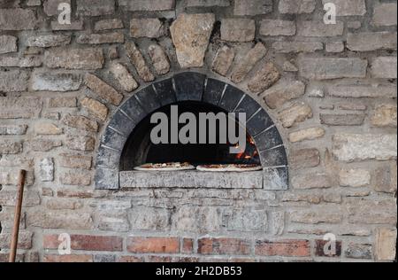 Steinofen im Freien mit zwei Pizzen zum Kochen Stockfoto