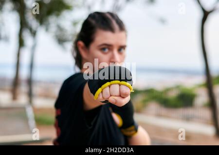 Nahaufnahme einer Frau mit Kung Fu-Handschuhen, die in einem Park trainiert Stockfoto