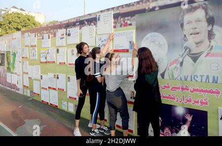 Prominente schreiben am Donnerstag, den 21. Oktober 2021, im Multiple Sports Center in Islamabad interessante moralisch aufmurrende Sätze für pakistanische Cricketspieler an die Wand des pakistanischen Cricket-Teams „We Love You“ für die Veranstaltung der ICC Men's T20 World Cup. Stockfoto