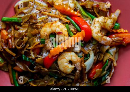 Betrunkene Nudeln, Pad kee mao, mit Garnelen, Basilikum, Chilli, Paprika und grüne Bohnen. Nahaufnahme auf einer Platte. Stockfoto