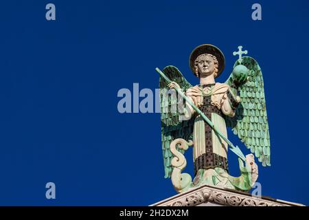 Der Erzengel Michael besiegt den Drachen, eine mittelalterliche Statue aus dem 13. Jahrhundert auf der Spitze der St. Michael Kirche in Lucca (mit blauem Himmel und Kopierraum) Stockfoto