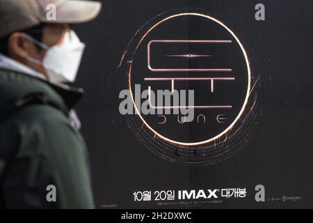 Seoul, Südkorea. Oktober 2021. Ein Mann, der eine Maske trägt, kommt an einer Plakatwand des Films "Dune" von Denis Villeneuve in Seoul vorbei.der Film "Dune" wurde am 20. Oktober 2021 in Südkorea veröffentlicht. Kredit: SOPA Images Limited/Alamy Live Nachrichten Stockfoto