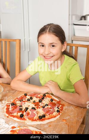 Das kleine Mädchen kochte ihre Lieblingspizza Stockfoto
