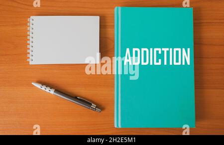 Tagebuch mit der Aufschrift Addiction auf dem Tisch mit Stift und Notizblock zum Schreiben Stockfoto