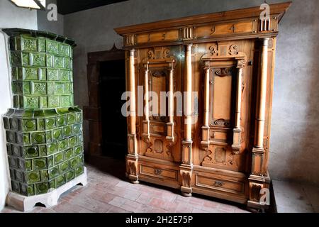 Alte Garderobenmöbel aus dem 16. Jahrhundert und Keramikofen im Château du Haut-Koenigsbourg oder im Schloss Haut-Koenigsbourg im Elsass in Frankreich Stockfoto