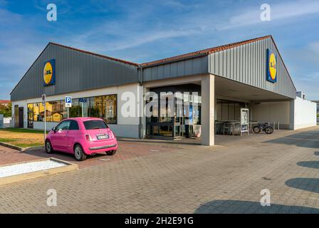 Fossano, Cuneo, Italien - 9. September 2021: LIDL Supermarkt mit pinkem 500 FIAT Auto auf dem Parkplatz, Lidl Stiftung & Co. KG. Stockfoto