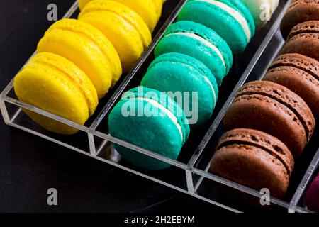 Bunte Makronen-Kekse in der Acrylbox Stockfoto