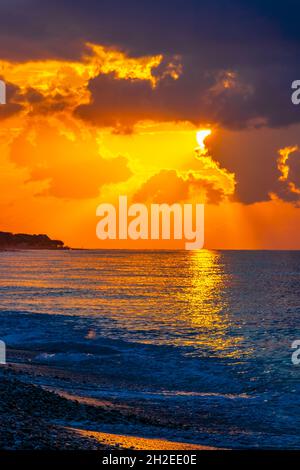 Goldene Farben des schönsten Sonnenuntergangs am Strand von Ialysos auf der griechischen Insel Rhodos. Stockfoto