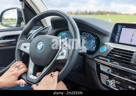 Nahaufnahme der weiblichen Hände am Lenkrad des Elektroautos BMW iX3. Schweden. Uppsals. Stockfoto