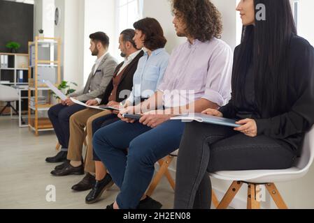 Fokussierte Kollegen, die bei einer Geschäftsschulung in Reihe sitzen und wirklich gute Informationen hören. Stockfoto