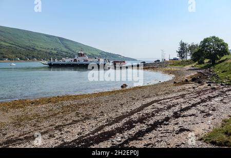 CALMAC Fähre 'Loch Dunvegan' Verladefahrzeuge für die Überquerung der Kyle of Bute nach Colintraive mit Kiesstrand im Vordergrund und Hitze dunstig Hintergrund Stockfoto