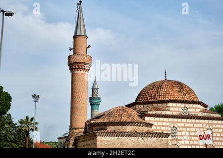 Seyh kutbuddin und sein Sohn Grab aus roten Ziegeln Wand mit seinem Minarett erstreckt sich auf blau bewölkten Himmel mit grünen Moschee (yesil Cami) Hintergrund. Stockfoto