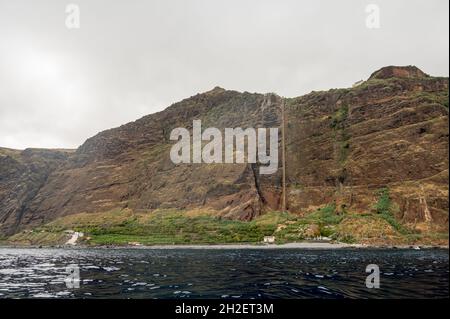 Panoramablick auf die schiere vulkanische Klippe, die sich über dem Ozean erhebt. Stockfoto