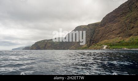 Panoramablick auf die schiere vulkanische Klippe, die sich über dem Ozean erhebt. Stockfoto