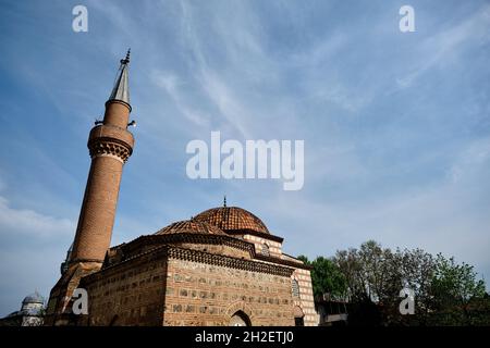 Seyh kutbuddin und sein Sohn Grab aus roten Ziegeln Wand mit seinem Minarett erstreckt sich auf blau bewölkten Himmel mit grünen Moschee (yesil Cami) Hintergrund. Stockfoto