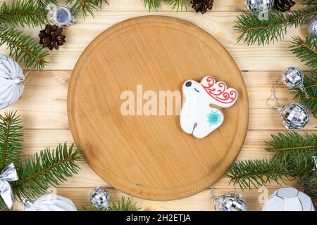 Holztablett mit Ästen aus Tannenbaum und Spielzeug auf natürlichem Holzhintergrund. Nachbau für Weihnachtsdekoration, Neujahrskarte. Stockfoto