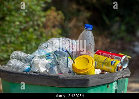 Überlaufender Recyclingbehälter voller Plastikflaschen und Aluminiumdosen. Recycling-Behälter, Abfallbehälter, Wiederverwendung von Kunststoffen, Recycling-Müll, Abfall. Stockfoto