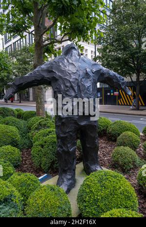 LONDON, GROSSBRITANNIEN - 10. Aug 2021: Eine vertikale Aufnahme einer Skulptur eines Mannes mit offenen Armen von Giles Penny in Canary Wharf, London, Großbritannien Stockfoto