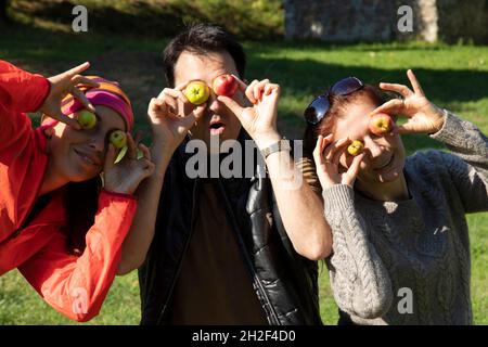 Lustige Freunde auf einem Spaziergang im Herbst, Mann und Frau Witz mit kleinen wilden Äpfeln Stockfoto