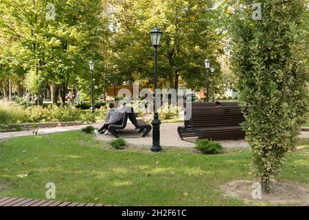 Slawjansk-on-Kuban, Russland - 14. September 2021: Ein kleiner grüner Platz mit Bänken zur Erholung in der südlichen Stadt Stockfoto