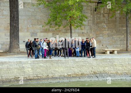 Eine große Gruppe von Personen auf einer geführten Tour, die vom Reiseleiter an der seine, Paris, Frankreich, angesprochen wird Stockfoto