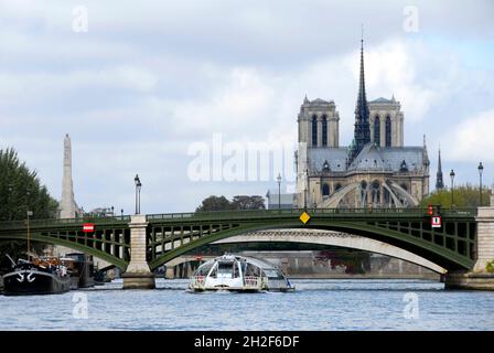 Pont de Sully, Paris, Frankreich mit der Kathedrale Notre-Dame und einem Ausflugsboot Stockfoto