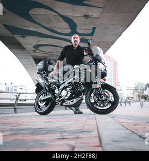 Juan Carlos Solarte posiert in der Stadt mit dem Motorrad Stockfoto