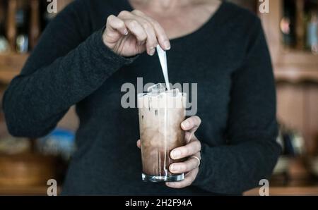 Mama macht zum Frühstück Eiskaffee zum Trinken Stockfoto