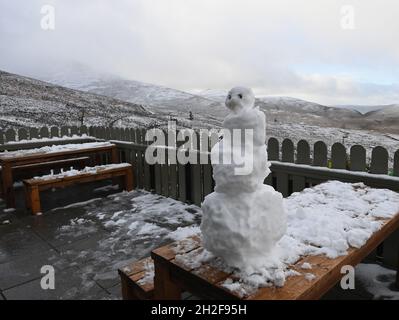 Cairngorms, Schottland, Großbritannien. 21-Okt-22 nach winterlichen Regenschauern fällt in Schottland Schnee. Cairngorm Mountain Range Snowman auf dem Balkon des Cairngorm Cafe Credit: eric mccowat/Alamy Live News Stockfoto