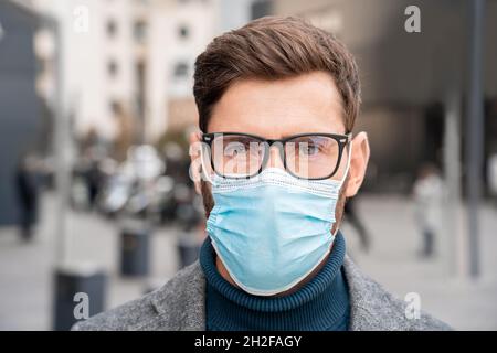 Gesicht Porträt des Geschäftsmannes tragen Gesichtsschutz medizinische Maske draußen Stockfoto