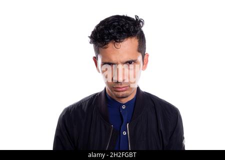 Lateinischer Mann mit wütendem Blick, isoliert auf weißem Hintergrund. Junger erwachsener mürrischer und wütender junger Mann. Stockfoto