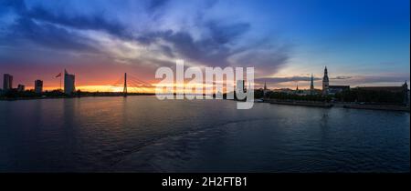 Panoramablick auf die Skyline von Riga und den Fluss Daugava bei Sonnenuntergang - Riga, Lettland Stockfoto