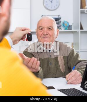 Mann, der im Büro ein Auto kauft Stockfoto