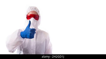 Der Arzt in einem Anzug, der sich vor einer Virusinfektion schützte, hob seinen Daumen hoch. Stockfoto