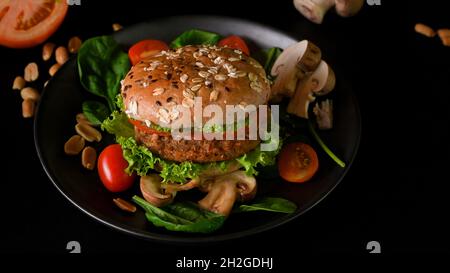 Saftiges veganes Burger-gegrilltes Cutlet mit gesundem Burgerbrötchen und frischem Gemüse. Pflanzliches Lebensmittelkonzept. Stockfoto