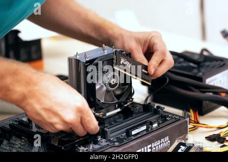 Zugeschnittenes Bild des Mannes, der Fury Beast-DDR4-Stick mit wahlfreiem Zugriff auf das Mainboard eines professionellen PCs für Kryptowährungsbergbau installiert. Russland, 17.08. Stockfoto