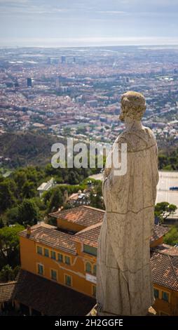 Steinstatue auf dem Dach der Kirche des Heiligen Herzens Jesu auf dem Gipfel des Parc Tibidabo in Barcelona, ​​Spain. Kathedralskulpturen, Luftaufnahme Stockfoto