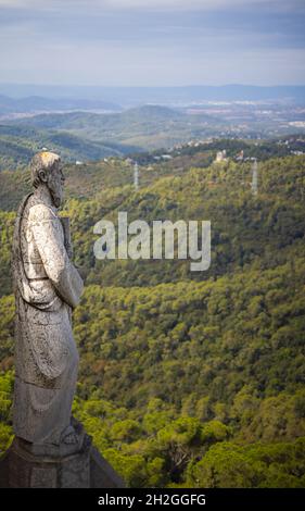 Steinstatue auf dem Dach der Kirche des Heiligen Herzens Jesu auf dem Gipfel des Parc Tibidabo in Barcelona, ​​Spain. Kathedralskulpturen, Luftaufnahme Stockfoto