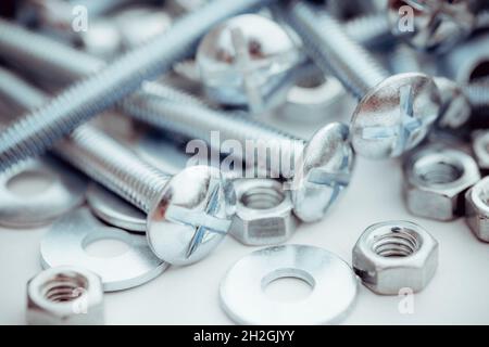 Hintergrund der Nahaufnahme neuer Schrauben und Muttern Stockfoto