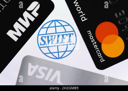 SWIFT ist das Netzwerk der Gesellschaft für weltweite Interbank Financial Telecommunication. Bankkarten mit Logos von drei Zahlungssystemen: Visa, Mastercard und mir Stockfoto