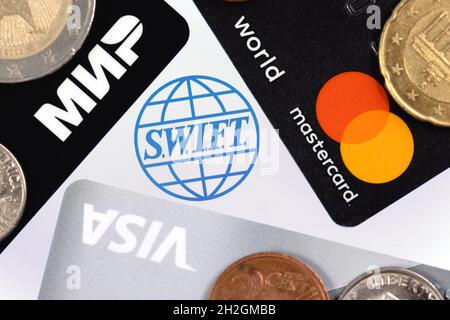 SWIFT ist das Netzwerk der Gesellschaft für weltweite Interbank Financial Telecommunication. Bankkarten mit Logos von drei Zahlungssystemen: Visa, Mastercard und mir Stockfoto