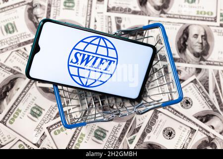 SWIFT ist das Netzwerk der Gesellschaft für weltweite Interbank Financial Telecommunication. SWIFT-Logo auf dem Smartphone-Bildschirm im Korb. Stockfoto