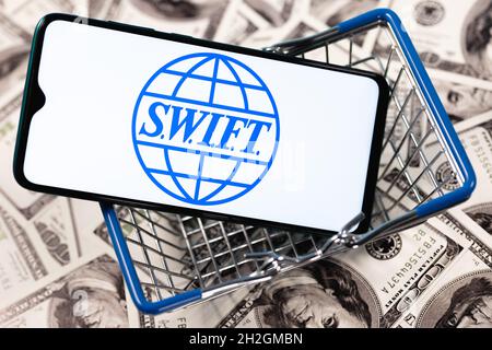 SWIFT ist das Netzwerk der Gesellschaft für weltweite Interbank Financial Telecommunication. SWIFT-Logo auf dem Smartphone-Bildschirm im Korb. Stockfoto