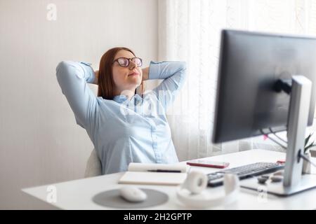 Glücklicher Schüler, der sich nach langer Zeit des Fernlernens am PC im Heimbüro entspannt. Stockfoto