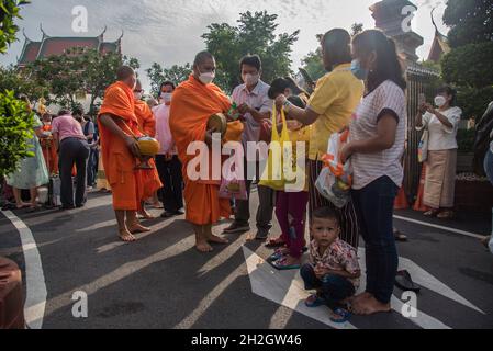 Thailändische buddhistische Anhänger mit Gesichtsmasken bieten dem thailändischen buddhistischen Mönch am Ende der Zeremonie des Buddhistischen Fastentages im Wat SaketBuddhistischer Fastentag ist ein Tag von religiöser Bedeutung für buddhistische Anhänger und markiert den Beginn der dreimonatigen Periode, Der Buddhistische Fastentag in Thailand begann am 25. Juli 2021 und endet am 21. Oktober 2021, als buddhistische Anhänger sich Verdiensten anschließen, um die Rückkehr des Buddha zur Erde zu feiern. Stockfoto