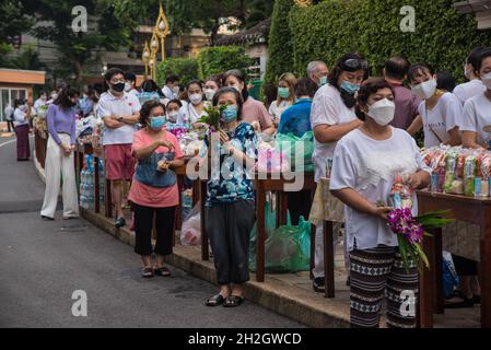 Thailändische buddhistische Anhänger mit Gesichtsmasken bieten dem thailändischen buddhistischen Mönch am Ende der Zeremonie des Buddhistischen Fastentages im Wat SaketBuddhistischer Fastentag ist ein Tag von religiöser Bedeutung für buddhistische Anhänger und markiert den Beginn der dreimonatigen Periode, Der Buddhistische Fastentag in Thailand begann am 25. Juli 2021 und endet am 21. Oktober 2021, als buddhistische Anhänger sich Verdiensten anschließen, um die Rückkehr des Buddha zur Erde zu feiern. (Foto von Peerapon Boonyakiat/SOPA Image/Sipa USA) Stockfoto