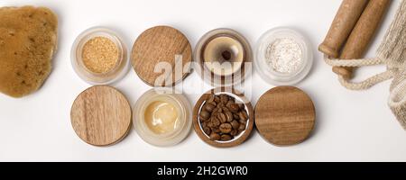 Braune Zucker-, Kaffee- und Honigzutaten zum Peeling in Glasgefäßen mit Holzdeckel, Peeling-Körpergurt, Meeresschwamm für die hausgemachte Gesundheitsversorgung. Schönheit, Stockfoto