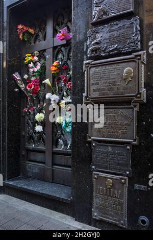 Vertikale schräge Ansicht des Marmorgrabes Eva Peron, voller Blumen und Ehrerbietung aus Metall, in ihrer Familiengruft, La Recoleta Cemetery, Buenos Aires Stockfoto