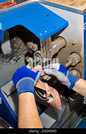 Junger Schuhmacher, der Schuhe in der Werkstatt flicken kann. Stockfoto